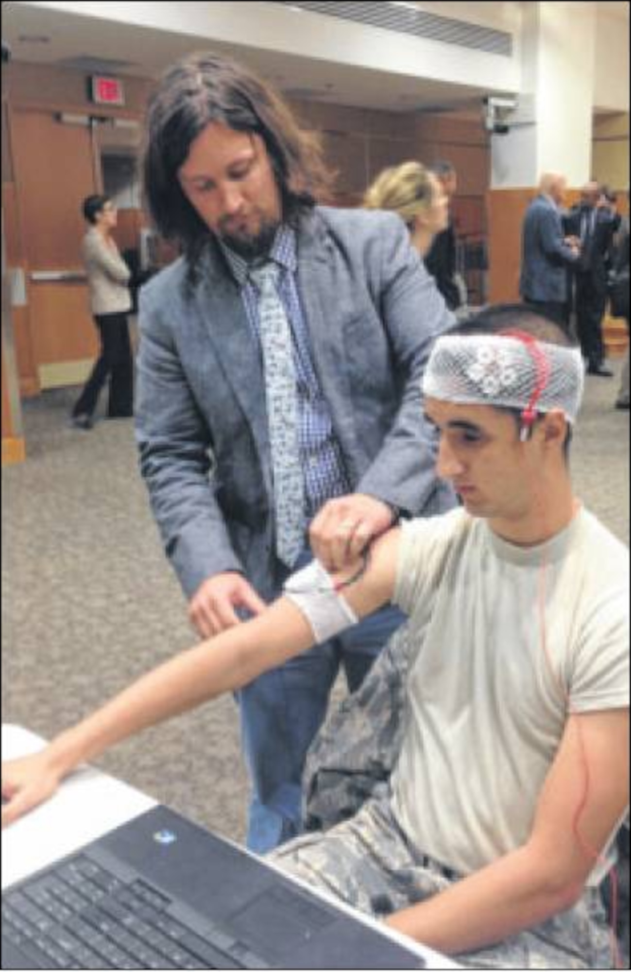 Dr, Richard McKinley (standing) and 2nd Lt. Brian Tabares demonstrate research on non-invasive use of transcranial, direct-current stimulation to improve cognitive functions. Both are assigned to the Air Force Research Laboratory's 711th Human Performance Wing. (Air Force photo by Bill Hancock)