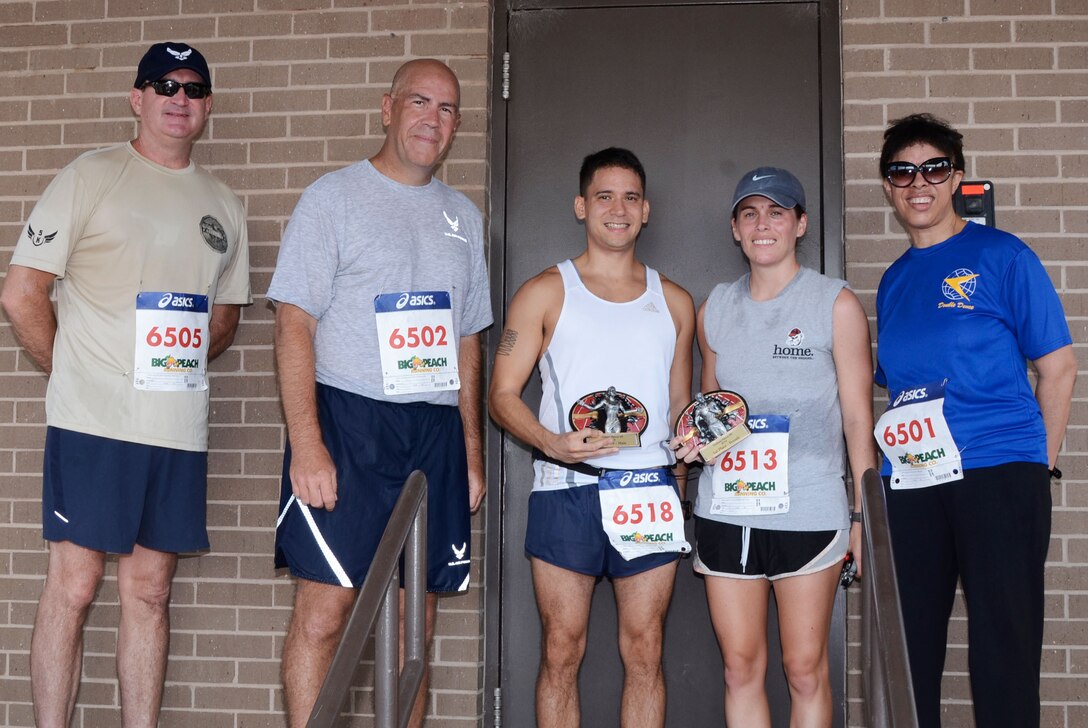 Chief Master Sgt. Chad Ronnebaum, 94th Airlift Wing command chief; Col. Brent Merritt, 94th Airlift Wing vice commander; Senior Airman David Flynn, 94th Aeromedical Staging Squadron; Senior Airman Jaqueline Harris, 94th Logistics Readiness Squadron vehicle mechanic; and Maj. Gen. Stayce Harris, 22nd Air Force commander, pose for a photo after the Falcon 5k Sept. 7, 2014, at Dobbins Air Reserve Base, Ga. Flynn and Harris were the first male and female finishers of the fun run sponsored by the Dobbins Top 3. (U.S. Air Force photo by Don Peek/Released)