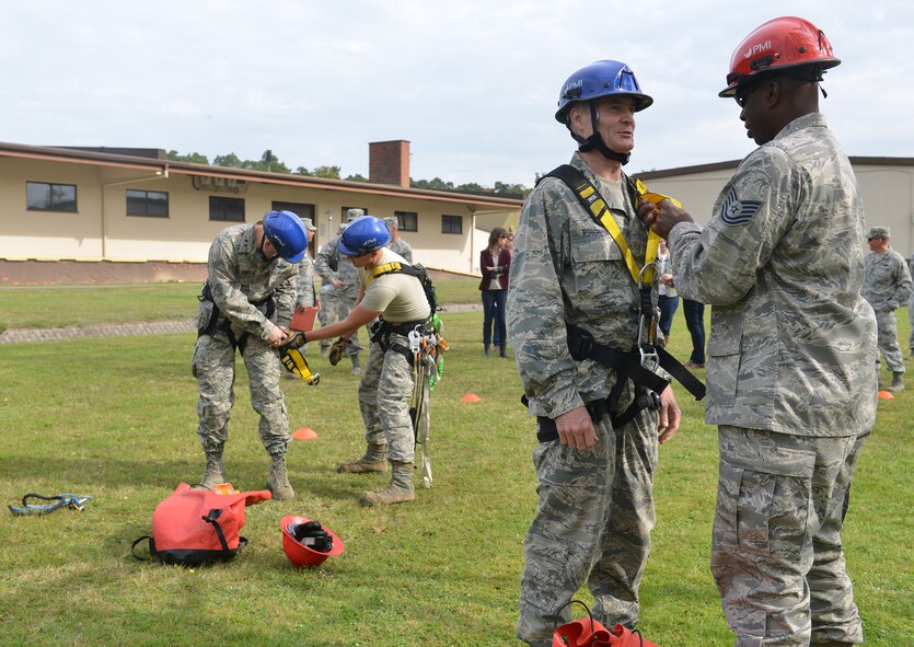 Tech. Sgt. William Liggins, 1st Communications Maintenance Squadron cable antenna systems team lead, helps Lt. Gen. Darryl Roberson, 3rd Air Force and 17th Expeditionary Air Force commander, put on safety equipment before he participates in a simulated rescue mission at a 1st CMXS communication tower during an immersion tour on Ramstein Air Base, Germany, Sept. 30, 2014. During his tour, Roberson learned about the day-to-day tasks of Airmen assigned to multiple units within the wing. The tour helped give him a better understanding of the wing’s operations and how it contributes to the overall Air Force mission in support of combatant commanders and national objectives. (U.S. Air Force photo/Senior Airman Holly Mansfield)