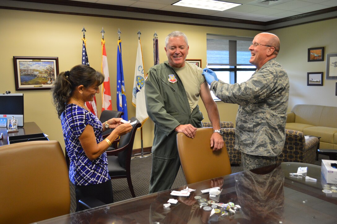 Lt. Gen. William Etter, Continental U.S. Northern Aerospace Defense Region-1st Air Force (Air Forces Northern) Commander, enjoys a light moment with his Deputy Command Surgeon General, Daizy Labee and the Command Surgeon General, Col. Bruce Woodford , as they administer his flu shot. Flu shots throughout the AFNORTH organization will be available later this month. (Photo by Mary McHale)