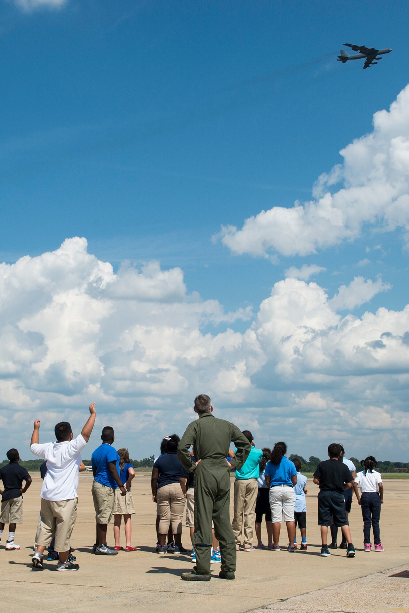 A group of STARBASE students watch as a B-52H Stratofortress flies by during a tour on Sept. 30, 2014, Barksdale Air Force Base, La. The STARBASE program is a 25-hour hands on/minds on environment that actively engages students in exploration of Science, Technology, Engineering and Mathematics to excite their interest, develop a solid concept base and encourage pursuit of these four fields for future careers. (U.S. Air Force photo by Master Sgt. Greg Steele/Released)