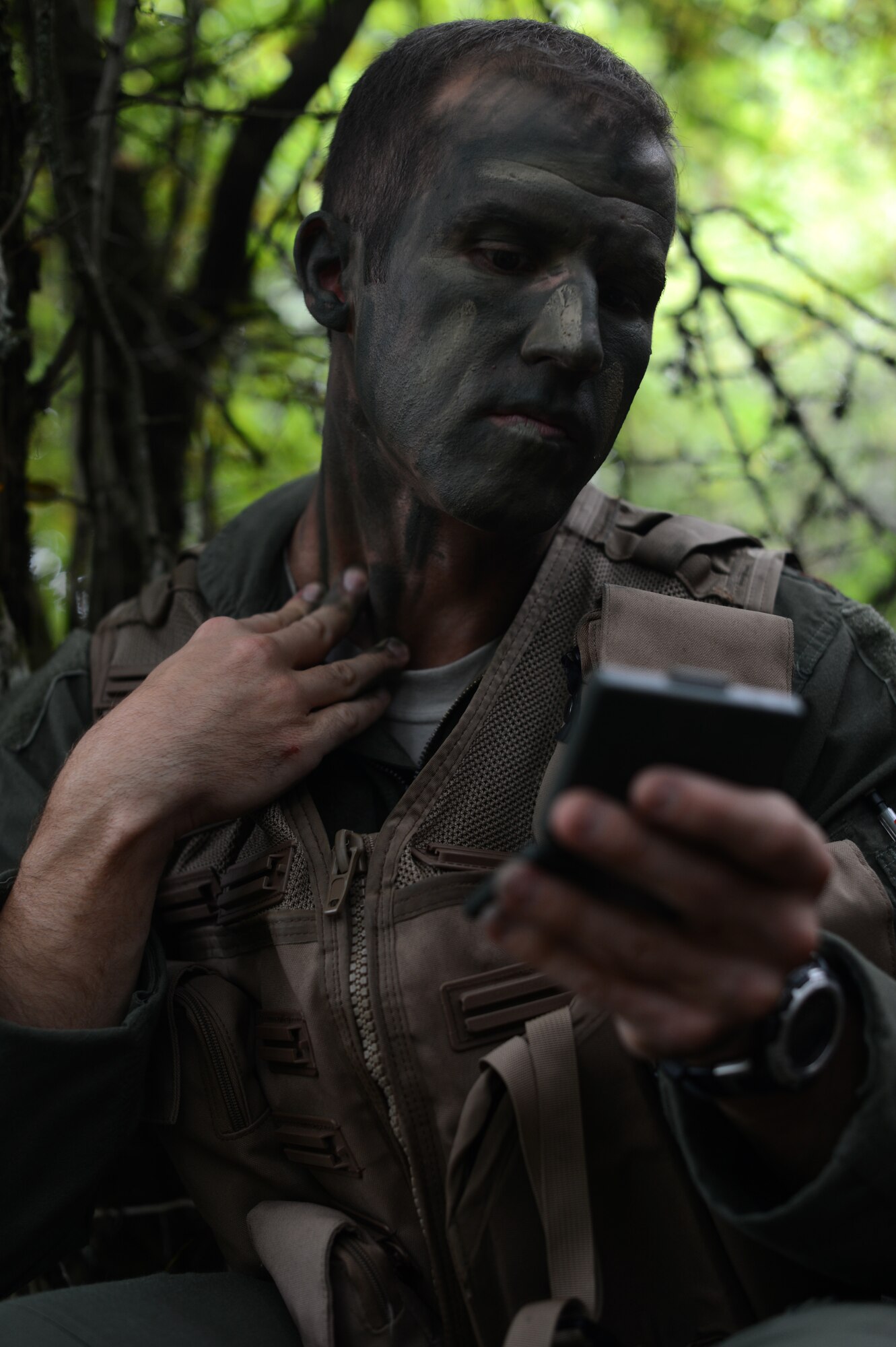 U.S. Air Force Maj. Bradley Sullivan, 480th Fighter Squadron pilot and native of Friendswood, Texas, applies camouflage during combat survival training on a range in Baumholder, Germany, Sept. 30, 2014.  Pilots learned the most effective styles and procedures for applying camouflage while understanding how to evade and hide from enemies. (U.S. Air Force photo by Senior Airman Gustavo Castillo/Released) 