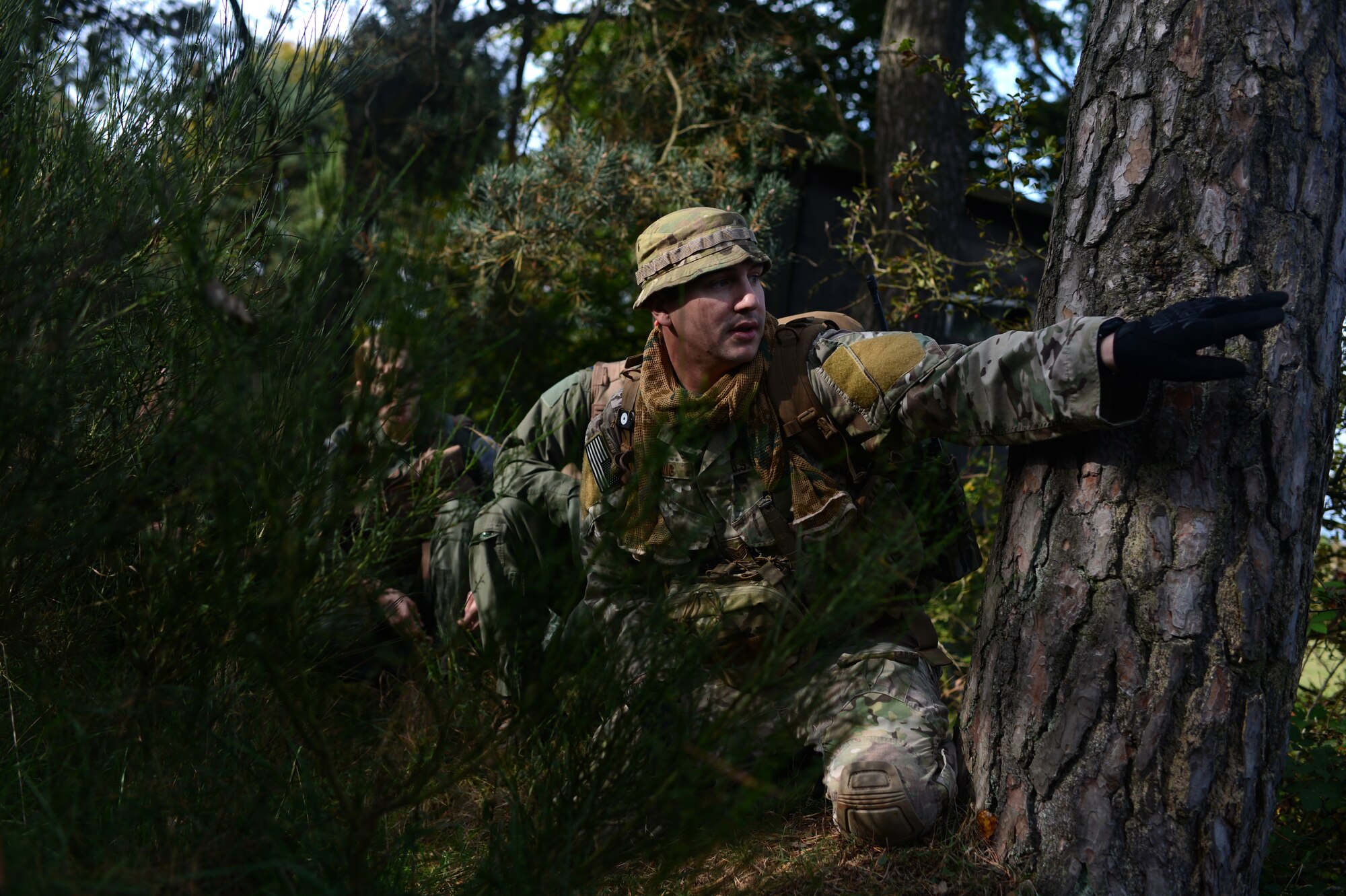 U.S. Air Force Tech. Sgt. John Long, 52nd Operations Support Squadron survival, evasion, resistance and escape NCO in charge of weapons and tactics, directs a group of pilots during combat survival training on a range in Baumholder, Germany, Sept. 30, 2014. Long facilitated training where pilots practiced survival techniques involving both weather complications and different detention circumstances. (U.S. Air Force photo by Senior Airman Gustavo Castillo/Released) 