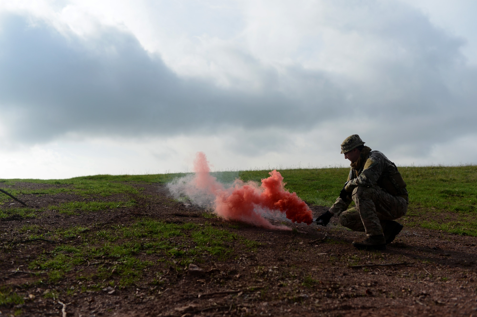 U.S. Air Force Tech. Sgt. John Long, 52nd Operations Support Squadron survival, evasion, resistance and escape NCO in charge of weapons and tactics, demonstrates the use of smoke signaling during combat survival training on a range in Baumholder, Germany, Sept. 30, 2014. SERE training provides high-risk-of-isolation personnel the necessary skills needed to survive in all types of environments. (U.S. Air Force photo by Senior Airman Gustavo Castillo/Released) 