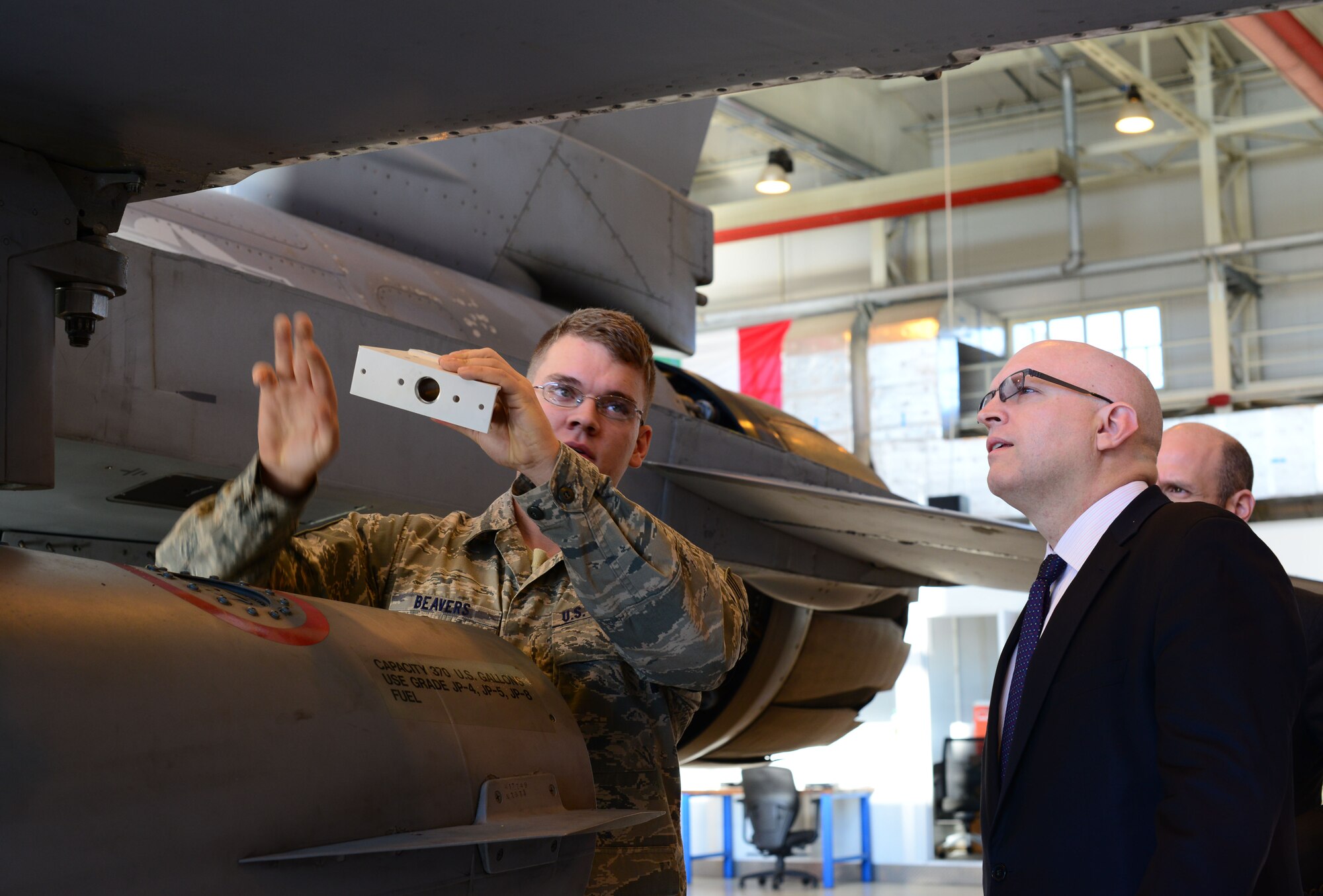 Staff Sgt. Andrew Beavers, 31st Maintenance Squadron phase floor chief, briefs Philip Reeker, U.S. Consul General, on the capabilities of the F-16 Fighting Falcon, Oct. 2, 2014, at Aviano Air Base, Italy. Reeker heads the U.S. Consulate General Milan, which serves northern Italy. (U.S. Air Force photo/Senior Airman Michael Battles)