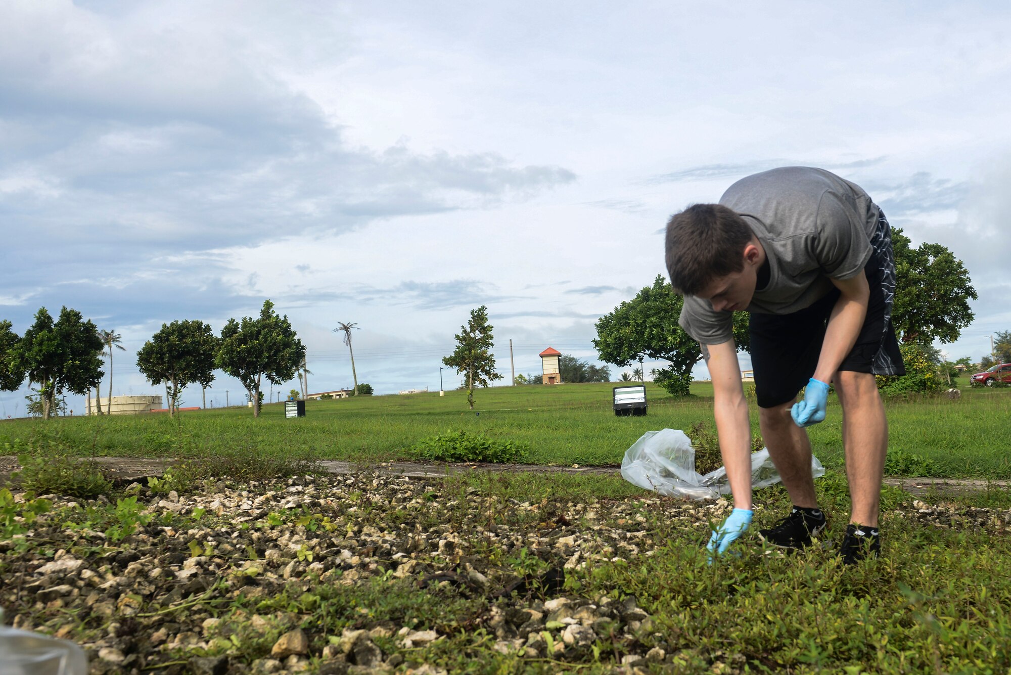 Airman 1st Class Andrew Rainey picks up debris during Operation Restore Heritage Oct. 1, 2014, on Andersen Air Force Base, Guam. Team Andersen Airmen picked up trash at the Arc Light Memorial and F-4E Phantom II site, to preserve Andersen’s history.  (U.S. Air Force photo by Airman 1st Class Adarius Petty/Released)