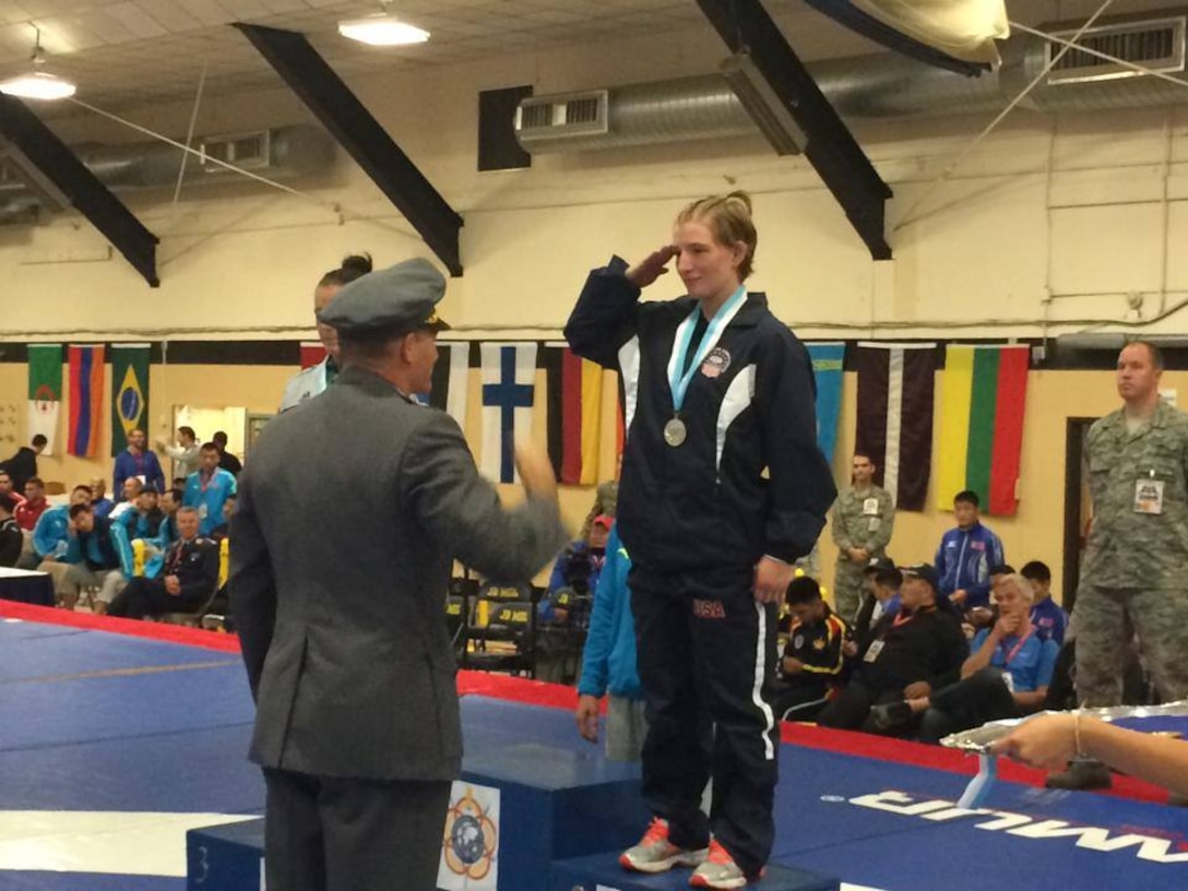 Army Sgt. Whitney Condor salutes the President of CISM Wrestling, Lt Col Marko Korpela (Finland) after receiving her silver medal during the 2014 CISM World Military Wrestling Championship at Joint Base McGuire-Dix-Lakehurst, New Jersey on 3 October 2014.