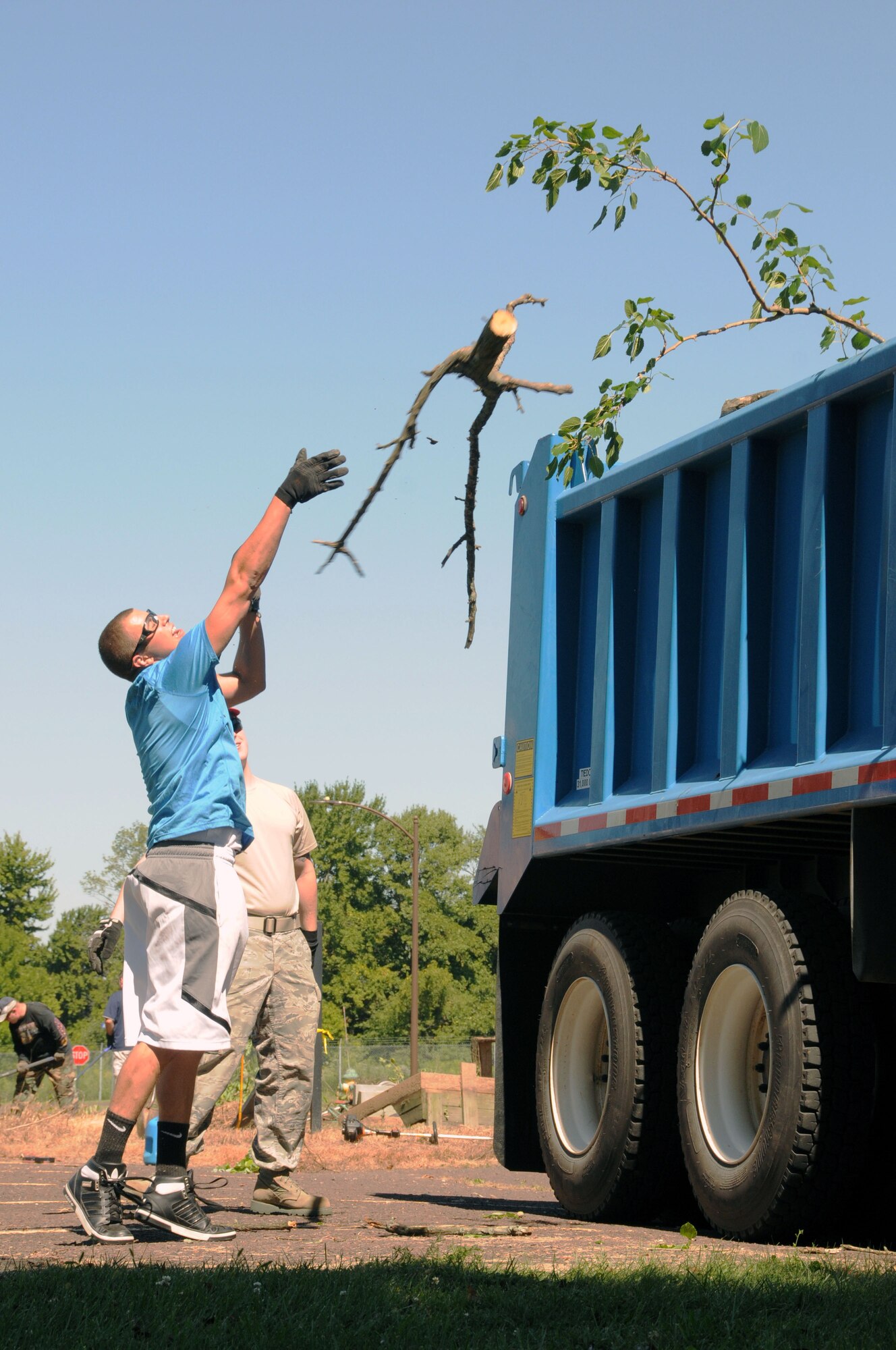 An Airmen from the 201st REDHORSE squadron of the 111th Attack Wing leaps upward to help remove downed tree limbs during a base clean-up day Aug. 28, 2014, Horsham Air Guard Station, Pa. Members across the wing joined together to enhance the base in preparation for the upcoming Environment, Safety and Occupational Health inspection slated for September. (U.S. Air National Guard photo by Tech. Sgt. Andria J. Allmond/Released)