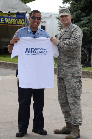 Master Sgt. Kevin Watson, 111th Attack Wing recruiting supervisor at Horsham Air Guard Station, Pa., gives an Air National Guard shirt to a festival employee Aug. 2, during the 30th Annual Musikfest in Bethleham, Pa. The festival composed of diverse music, artisans and vendors boasts thousands of visitors and Pennsylvania residents; the wing’s recruiting office chose not to miss the opportunity to connect with a local audience. (U.S. Air National Guard photo by Master Sgt. Chris Botzum/Released)
