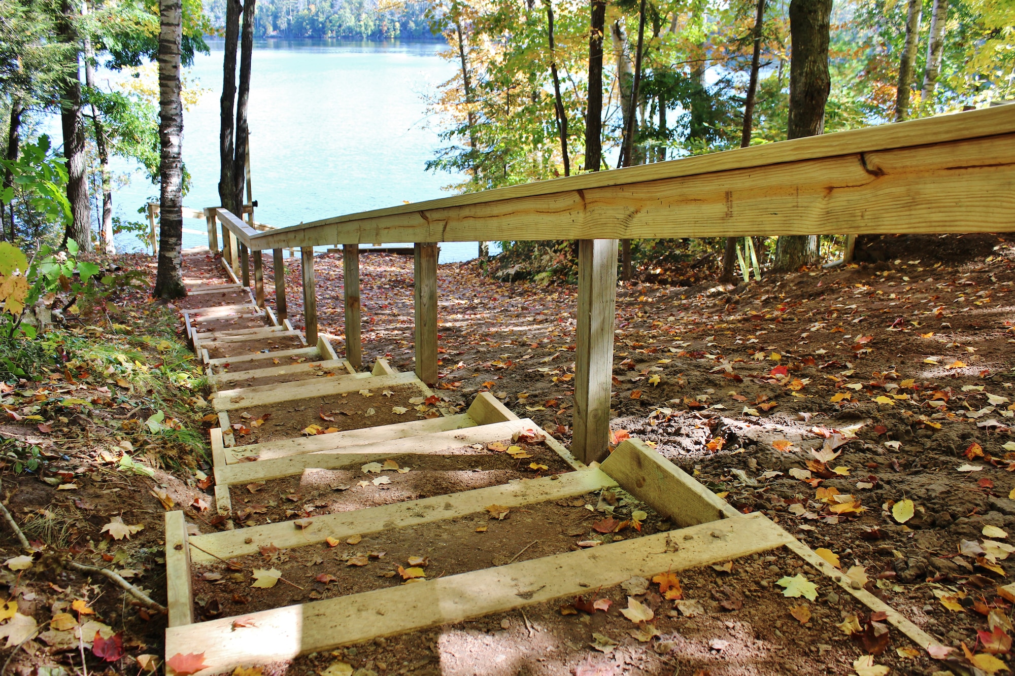 U.S. Airmen with the civil engineering squadron of the 128th Air Refueling Wing, Wisconsin Air National Guard replaced the stairs to a dock on the lake and added new hand rails during the renovation of a cabin at Camp American Legion in Lake Tomahawk, Wis. Sept. 26, 2014.  (U.S. Air National Guard photo by Staff Sgt. Josh Garringer/Released)