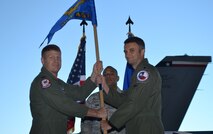 Colonel James McCune, 495th Fighter Group commander, left, presents the Detachment 457 guidon to Lt. Col. Jeffrey Cunningham, the detachment's new commander, during the Assumption of Command ceremony October 3.  Detachment 457 is an active associate unit assigned to the 301st Fighter Wing at Naval Air Station Ft. Worth Joint Reserve Base, Texas.