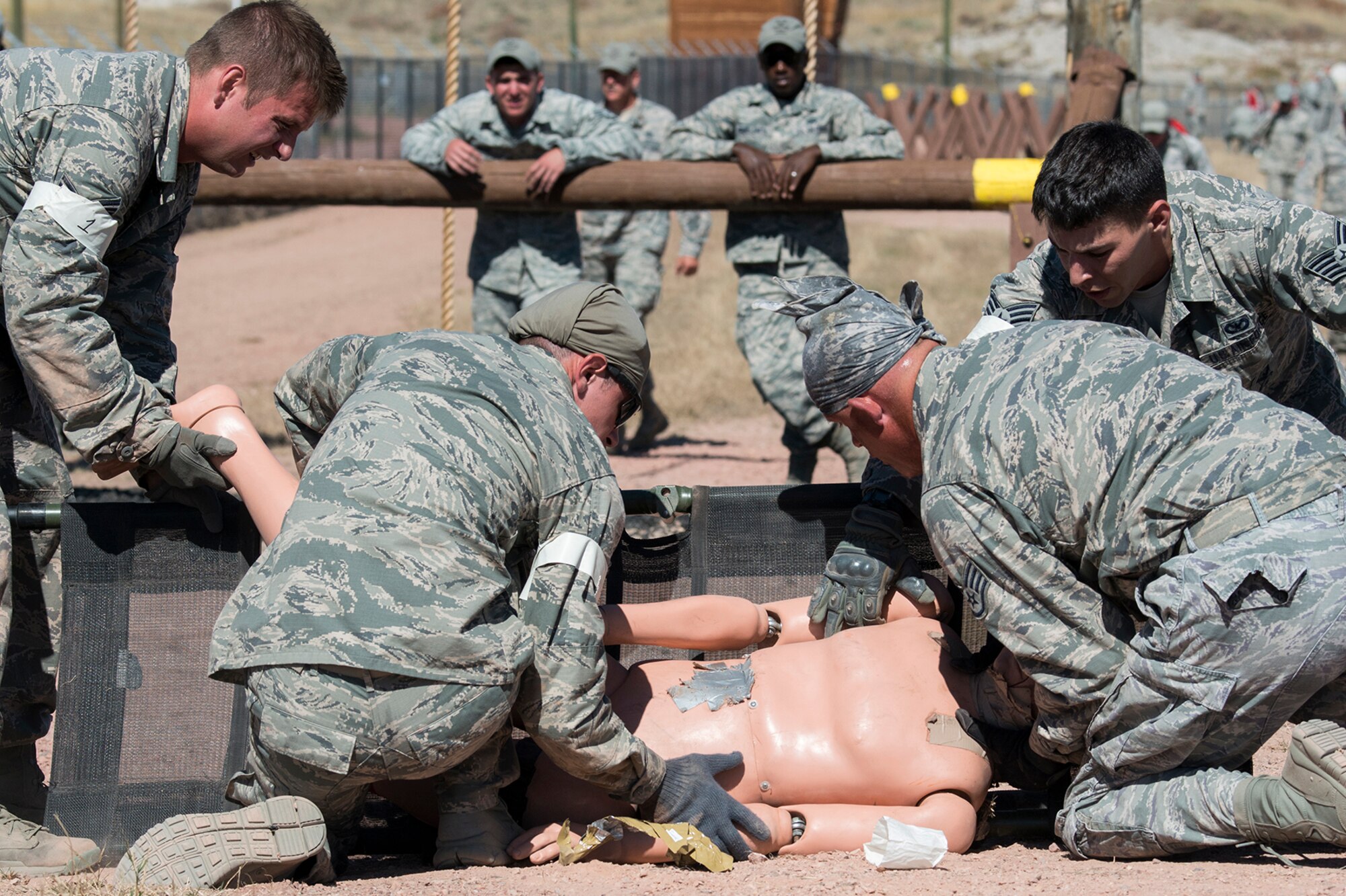 Members of the 307th Security Forces Squadron Global Strike Challenge team, work together to perform Self-Aid and Buddy Care techniques on a life-size dummy during the Mental and Physical competition, Sept. 25, 2014, Camp Guernsey, Wyo. The Global Strike Challenge is the world's premier bomber, Intercontinental Ballistic Missile, helicopter operations and security forces competition with units from Air Force Global Strike Command, Air Combat Command, Air Force Reserve Command and the Air National Guard. (U.S. Air Force photo by Master Sgt. Greg Steele/Released)