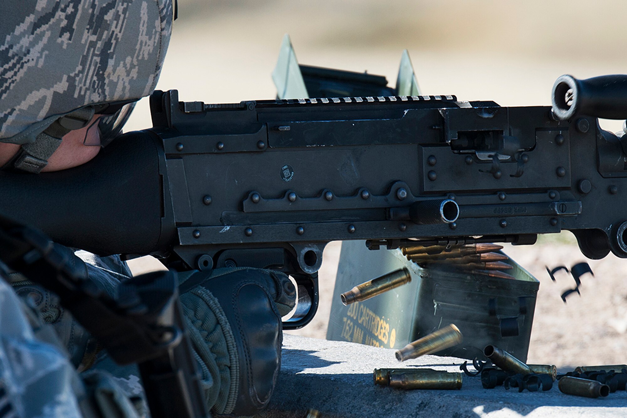 Empty shell casing are ejecting from a M240 machine gun as it's fired by U.S. Air Force Staff Sgt. Robert Cerami, 307th Security Forces Squadron, during the Global Strike Challenge Weapons Firing competition, Sept. 24, 2014, Camp Guernsey, Wyo. The Global Strike Challenge is the world's premier bomber, Intercontinental Ballistic Missile, helicopter operations and security forces competition with units from Air Force Global Strike Command, Air Combat Command, Air Force Reserve Command and the Air National Guard. (U.S. Air Force photo by Master Sgt. Greg Steele/Released)