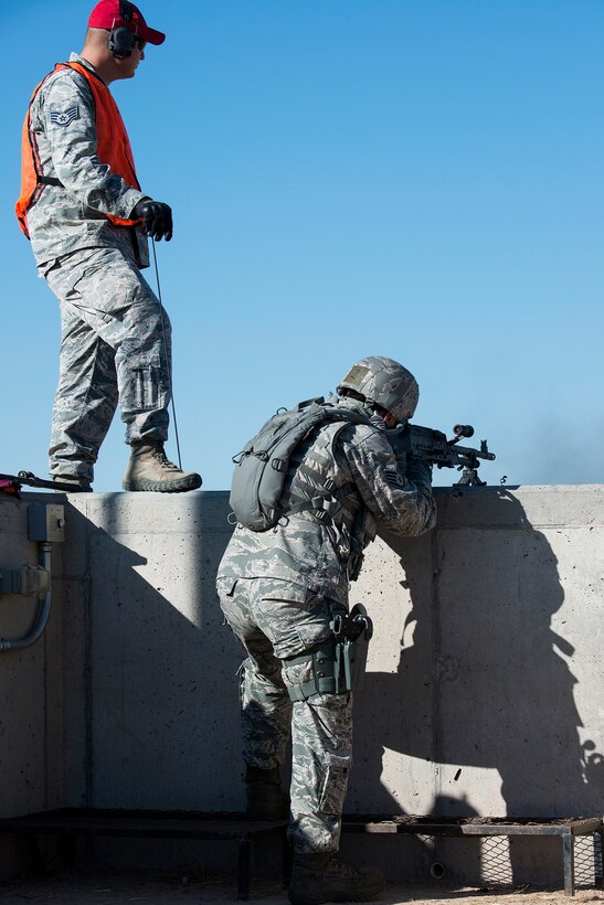 A Combat Arms observer watches down range as U.S. Air Force Staff Sgt. Robert Cerami, 307th Security Forces Squadron, fires an M240 machine gun during the Global Strike Challenge Weapons Firing competition, Sept. 24, 2014, Camp Guernsey, Wyo. The Global Strike Challenge is the world's premier bomber, Intercontinental Ballistic Missile, helicopter operations and security forces competition with units from Air Force Global Strike Command, Air Combat Command, Air Force Reserve Command and the Air National Guard. (U.S. Air Force photo by Master Sgt. Greg Steele/Released)