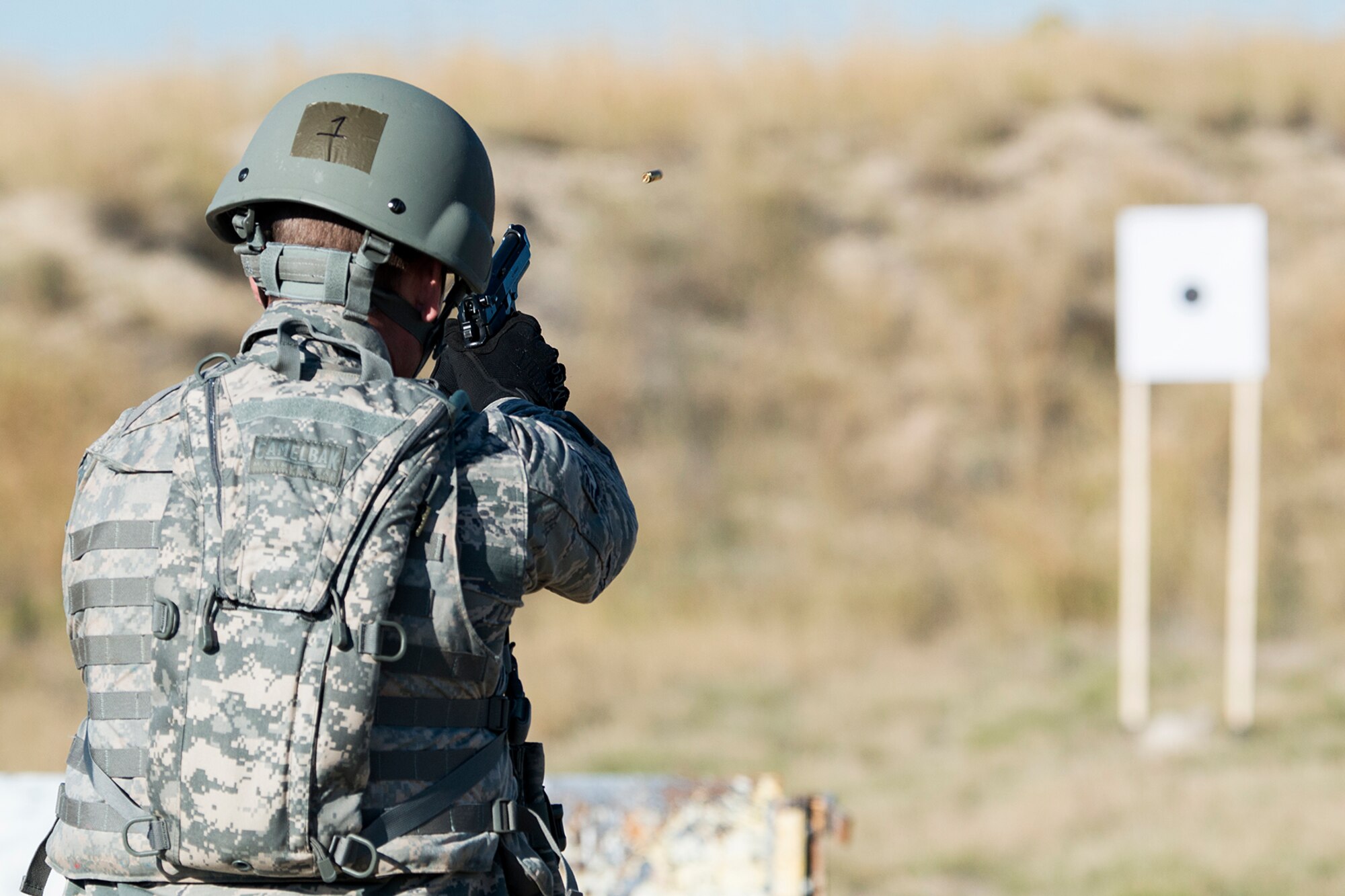 U.S. Air Force Staff Sgt. Johnathan Maupin fires his M9 handgun during the Global Strike Challenge Weapons Firing competition, Sept. 24, 2014, Camp Guernsey, Wyo. The Global Strike Challenge is the world's premier bomber, Intercontinental Ballistic Missile, helicopter operations and security forces competition with units from Air Force Global Strike Command, Air Combat Command, Air Force Reserve Command and the Air National Guard. (U.S. Air Force photo by Master Sgt. Greg Steele/Released)