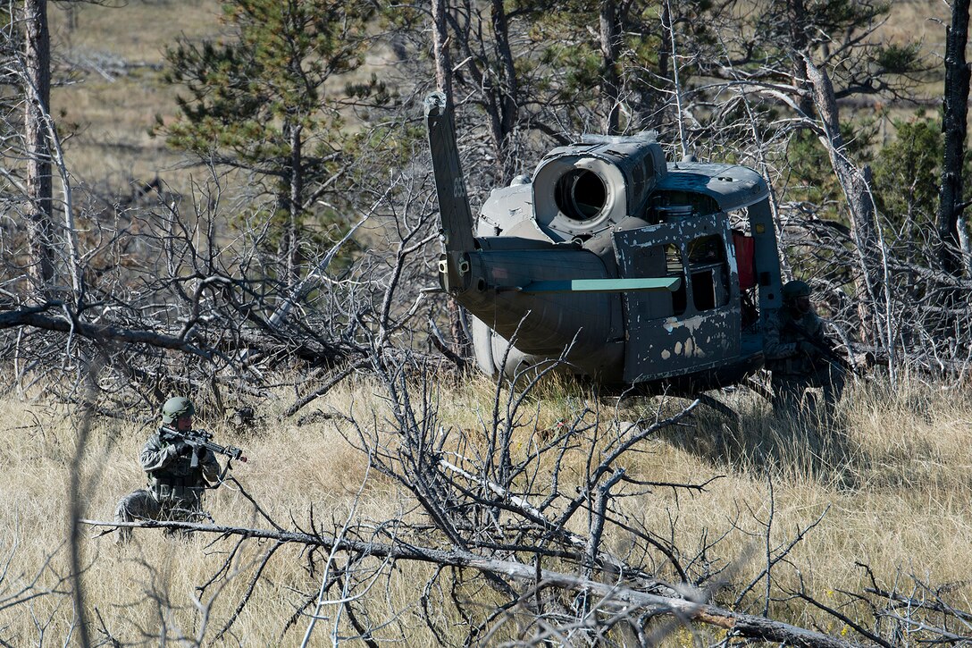 Two members of the 307th Security Forces Squadron secure a downed helicopter during the Global Strike Challenge Tactical competition, Sept. 23, 2014, Camp Guernsey, Wyo. The Global Strike Challenge is the world's premier bomber, Intercontinental Ballistic Missile, helicopter operations and security forces competition with units from Air Force Global Strike Command, Air Combat Command, Air Force Reserve Command and the Air National Guard. (U.S. Air Force photo by Master Sgt. Greg Steele/Released)