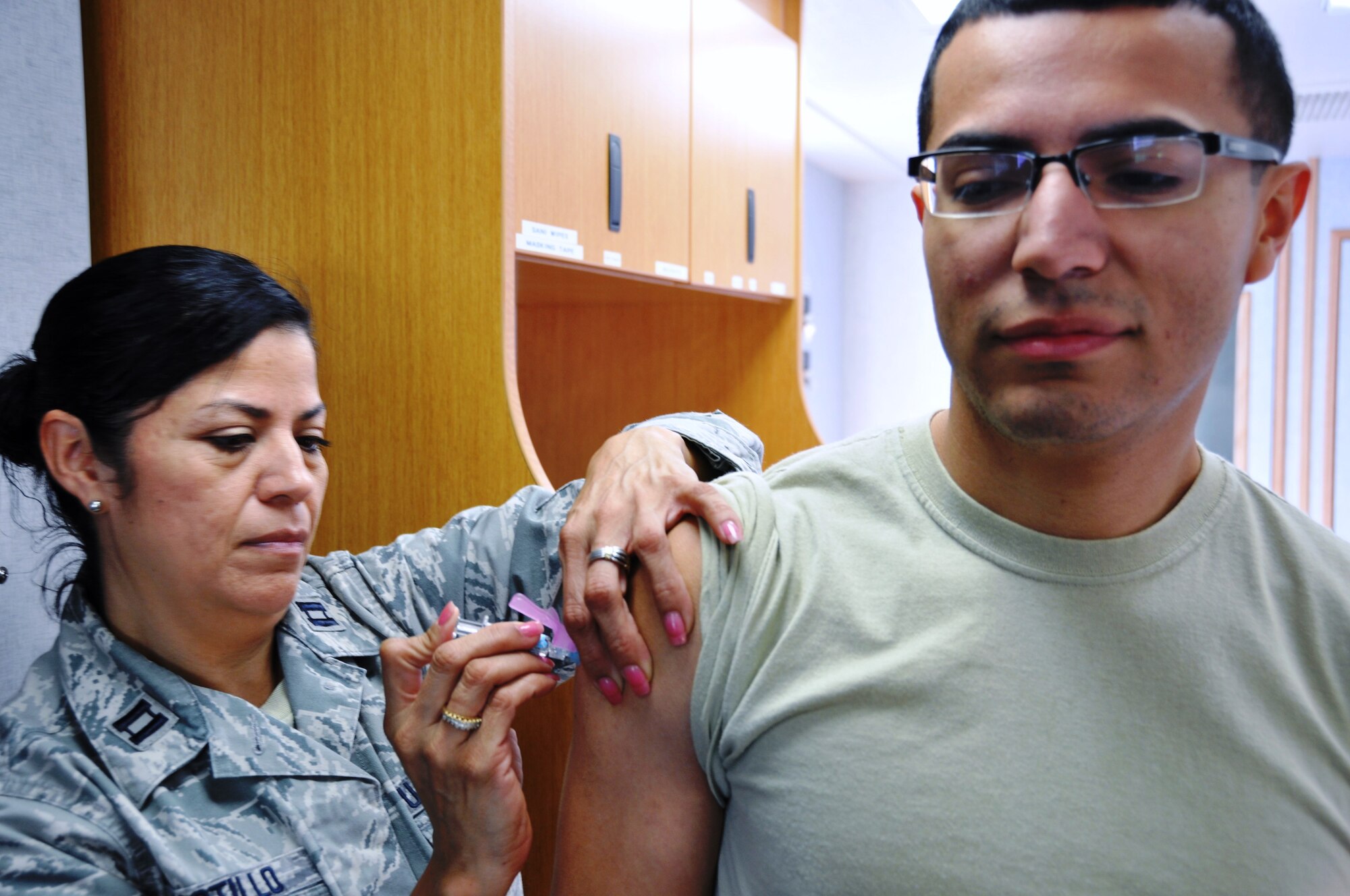 Capt. Elvira Castillo, 433rd Aerospace Medicine Squadron, injects Senior Airman Isaac Arriaga with a flu vaccine during the 433rd Airlift Wing's Unit Training Assembly on Oct. 4, 2014 at Joint Base San Antonio-Lackland, Texas.  The medics also passed out complimentary hand sanitizer and reminded wing members about hygiene as the nation enter the flu season.  (U.S. Air Force photo by Tech Sgt. Carlos J. Trevino)
