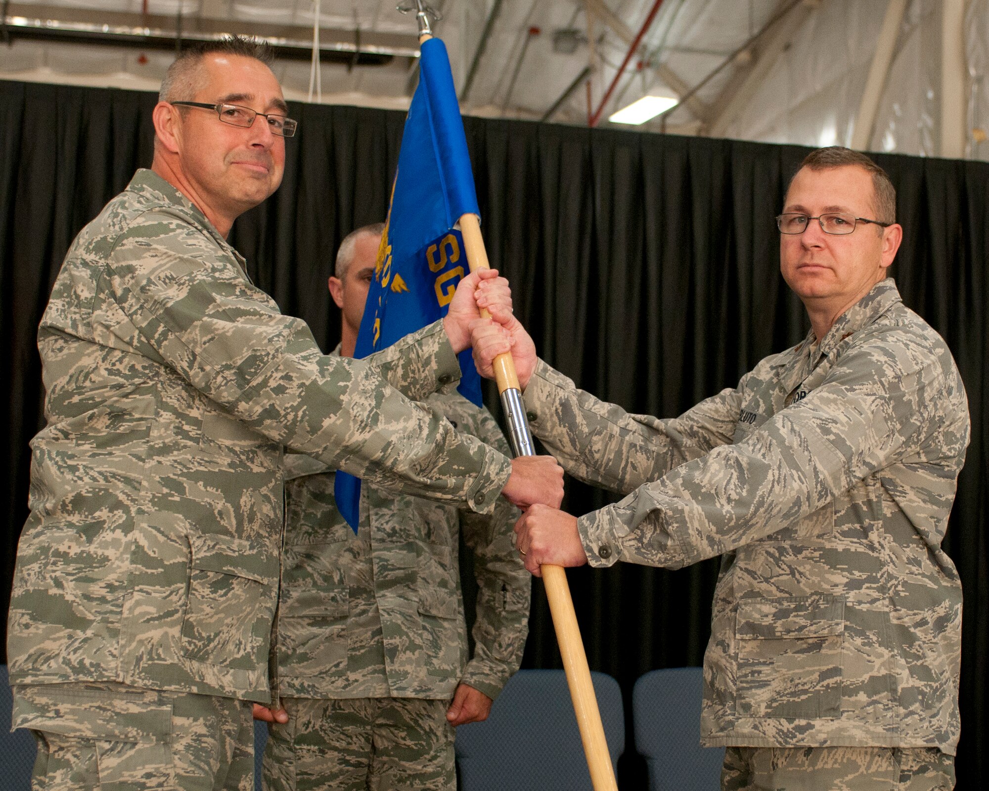 Maj. Jassen Bluto (right) accepts the 157th Security Forces Squadron gudion from Col. Paul Loiselle, 157th Mission Support Group commander, during the squadron's change of command ceremony at Pease Air National Guard Base, N.H., Oct. 3, 2014.  Bluto took command of the squadron from outgoing commander, Maj. Kenneth Leedberg.  (U.S. Air National Guard photo by Staff Sgt. Curtis J. Lenz)
