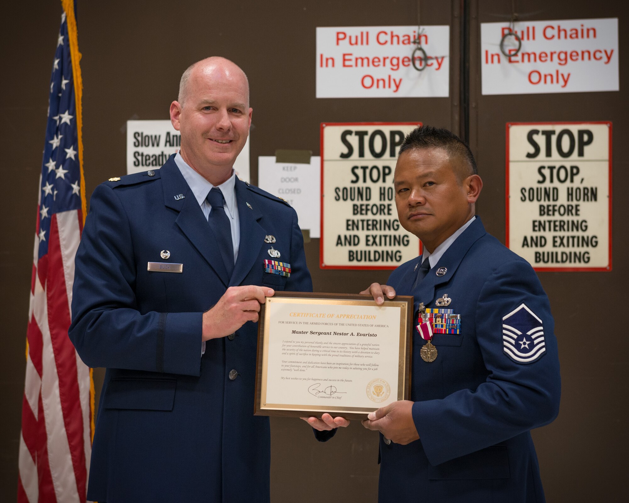 Maj. Edward Buck, 27th Aerial Port Squadron commander, presents Master Sgt. Nestor Evaristo with his Certificate of Appreciation from President Barack Obama during his retirement ceremony.  MSgt. Evaristo retired after 33 years of service during the October Unit Training Assembly weekend at the Minneapolis-St. Paul Air Reserve Station, Minn.  (U.S. Air Force photo by Tech. Sgt. Phil Velasco/Released)
