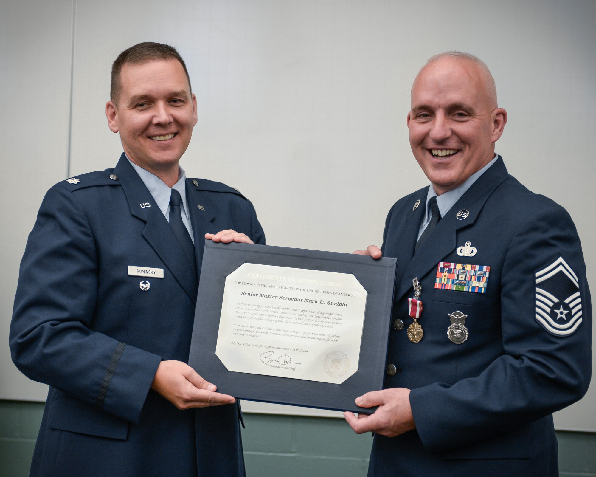 Lt. Col. Ted Ruminsky, former commander of the 934th Security Forces Squadron, presents Senior Master Sgt. Mark Stodola with a Certificate of Appreciation from President Barack Obama during his retirement ceremony today at the Minneapolis-St. Paul Air Reserve Station, Minn.  (U.S. Air Force photo by Paul Zadach/Released)