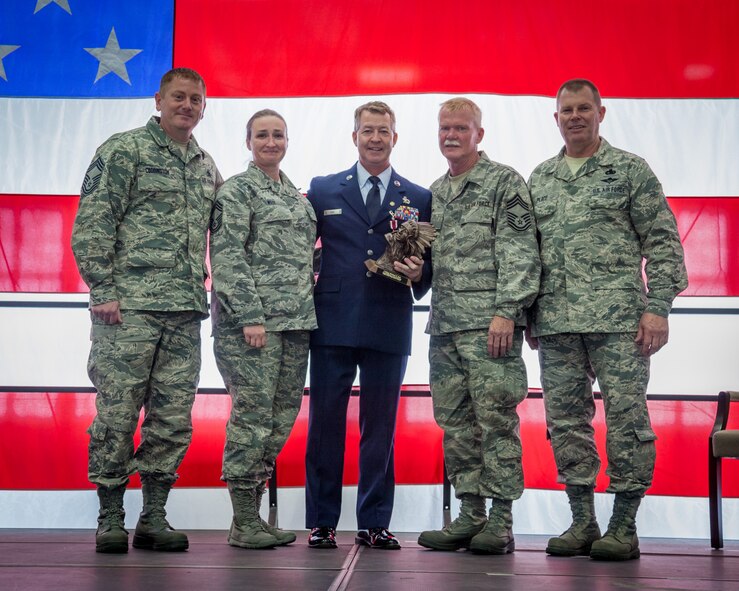 Members of the Chiefs' Council, (left to right) Chief Master Sgts. Frank Coddington, Tuppence Weix, Ron Welp, and Dale Place present Chief Master Sgt. Michael Rak (center) with a parting gift during his retirement ceremony at the Minneapolis-St. Paul Air Reserve Station, Minn.  (U.S. Air Force photo by Shannon McKay/Released)