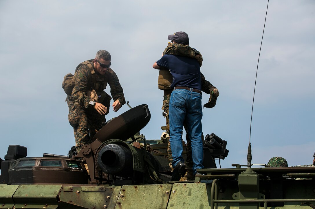 NAVAL EDUCATION AND TRAINING COMMAND, ZAMBALES, LUZON, Philippines – Barrett O. Comiskey hugs his brother on top of an Amphibious Assault Vehicle during a surprise family reunion at a mechanized assault that was part of Amphibious Landing Exercise 15 here, Oct. 5. Barrett traveled with his family from Taipei, Taiwan to the Philippines to surprise his brother after they had not seen each other for over a year. His brother, 1st Lt. William D. Comiskey, is an Amphibious Assault Vehicle platoon commander with Company I, Battalion Landing Team 3rd Battalion, 5th Marines, 31st Marine Expeditionary Unit. PHIBLEX is an annual, bilateral training exercise conducted by members of the Armed Forces of the Philippines alongside U.S Marine and Navy forces. 