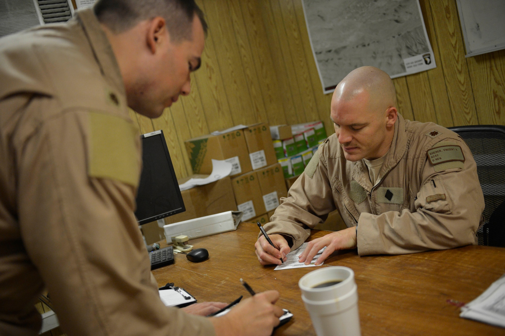 (Right) U.S. Air Force Maj. Vincent Sherer, 455th Ai r Expeditionary Wing, A-10 Thunderbolt II pilot, reviews checklists before a sortie at Bagram Airfield, Afghanistan Aug. 5, 2014.  Sherer has been flying for 12 years and has deployed to Bagram four times.  He is deployed from Davis-Monthan Air Force Base, Ariz. and a native of Portland, Ore. (U.S. Air Force photo by Staff Sgt. Evelyn Chavez/Released)