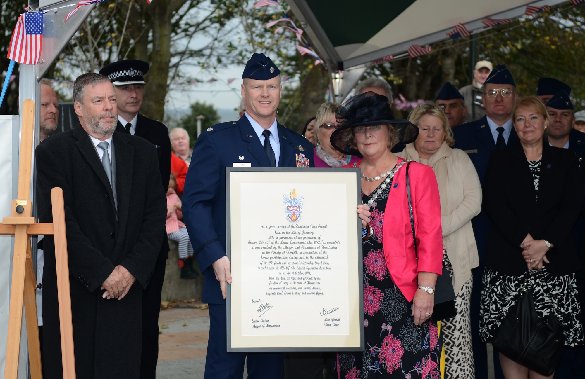 U.S. Air Force Lt. Col. John Peak, center, 67th Special Operations Squadron commander, receives the Freedom of Hunstanton from Counsillor Carol Bower, mayor of Hunstanton, Oct. 4, 2014, in Hunstanton, England. This is the highest award the town council is able to deliver to commemorate the lives saved by 67th Air Rescue Squadron Airmen during a flood in 1953. (U.S. Air Force photo/Airman 1st Class Kyla Gifford/Released)