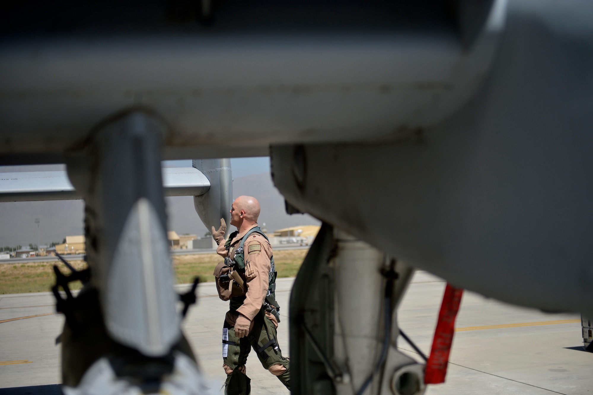 U.S. Air Force Maj. Vincent Sherer, 455th Air Expeditionary Wing pilot, inspects an A-10 Thunderbolt II aircraft at Bagram Airfield, Afghanistan Aug. 5, 2014.  Sherer flies the A-10 to provide overwatch and close air support to ground forces. Sherer is deployed from Davis-Monthan Air Force Base, Ariz. and a native of Portland, Ore. (U.S. Air Force photo by Staff Sgt. Evelyn Chavez/Released)
