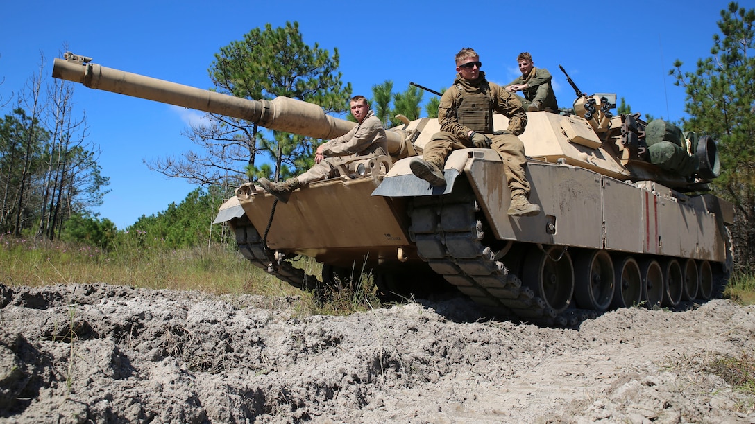 Cpl. Zachery Fowler (center) a gunner with 2nd Tank Battalion, 2nd Marine Division, and Estillfork, Ala., native, takes a short break with his team after they performed a patrol to look for simulated hostiles at Landing Zone Hawk aboard Marine Corps Base Camp Lejeune, N.C., Sept. 29, 2014. Fowler’s company performed maneuver exercises Sept. 28 through Oct. 2, 2014 to sharpen their basic skills and improve team camaraderie. “For mission readiness, it’s important that we have good cohesion inside the tank,” said Fowler.