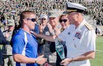 Vice Chairman of the Joint Chiefs of Staff Adm. James A. Winnefeld Jr. presents Warrior Games Ultimate Champion Air Force veteran Mitchell Keiffer with a trophy during halftime at the Air Force versus Navy football game at the U.S. Air Force Academy's Falcon Stadium in Colorado Springs, Colorado, Oct. 4, 2014. DoD photo by Army Staff Sgt. Sean K. Harp/Released