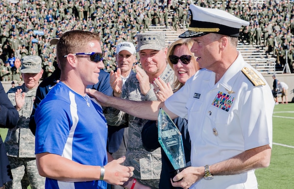 Vice Chairman of the Joint Chiefs of Staff Adm. James A. Winnefeld Jr. presents Warrior Games Ultimate Champion Air Force veteran Mitchell Keiffer with a trophy during halftime at the Air Force versus Navy football game at the U.S. Air Force Academy's Falcon Stadium in Colorado Springs, Colorado, Oct. 4, 2014. DoD photo by Army Staff Sgt. Sean K. Harp/Released