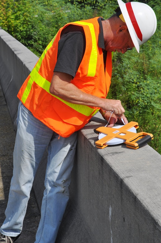 Joseph Brubaker, 542nd Engineer Detachment Forward Engineering Support Team - Advanced (FEST-A) electrical engineer, measures the height of a bridge during a bridge reconnaissance exercise on Hunter Army Airfield Sept. 18. The team gathered Sept. 15-25 to conduct training exercises to ensure deployment readiness by January 2015. FEST-A  is an all-volunteer team of engineers specializing in civil, mechanical, electrical, topography, and environmental engineering(USACE photo by Chelsea Smith). 