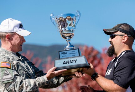 Chairman of the Joint Chiefs of Staff Gen. Martin E. Dempsey presents the Chairman's Cup trophy to the Army team captain Frank Barroquiero during the Warrior Games tailgate celebration at the U.S. Air Force Academy's Falcon Stadium in Colorado Springs, Colo., Oct. 4, 2014. The Chairman's Cup is awarded to the top-performing service branch at the Warrior Games. The Army’s win broke a four-year streak for the Marine Corps.