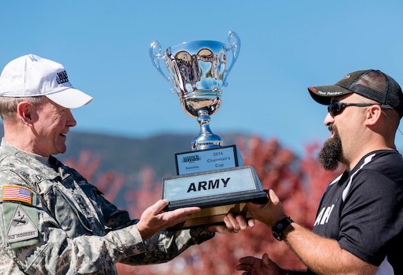 Chairman of the Joint Chiefs of Staff Gen. Martin E. Dempsey presents the Chairman's Cup trophy to the Army team captain Frank Barroquiero during the Warrior Games tailgate celebration at the U.S. Air Force Academy's Falcon Stadium in Colorado Springs, Colo., Oct. 4, 2014. The Chairman's Cup is awarded to the top-performing service branch at the Warrior Games. The Army’s win broke a four-year streak for the Marine Corps.