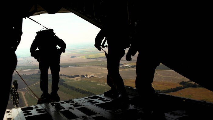 Critical skills operators with Marine Corps Forces Special Operations Command exit the back of a KC-130J Super Hercules during bilateral static-line jump training over a drop zone near Memphis, Tenn., Sept. 29, 2014. Marine Aerial Refueler Transport Squadron 252 supported the MARSOC Marines who were conducting long-range raid training.