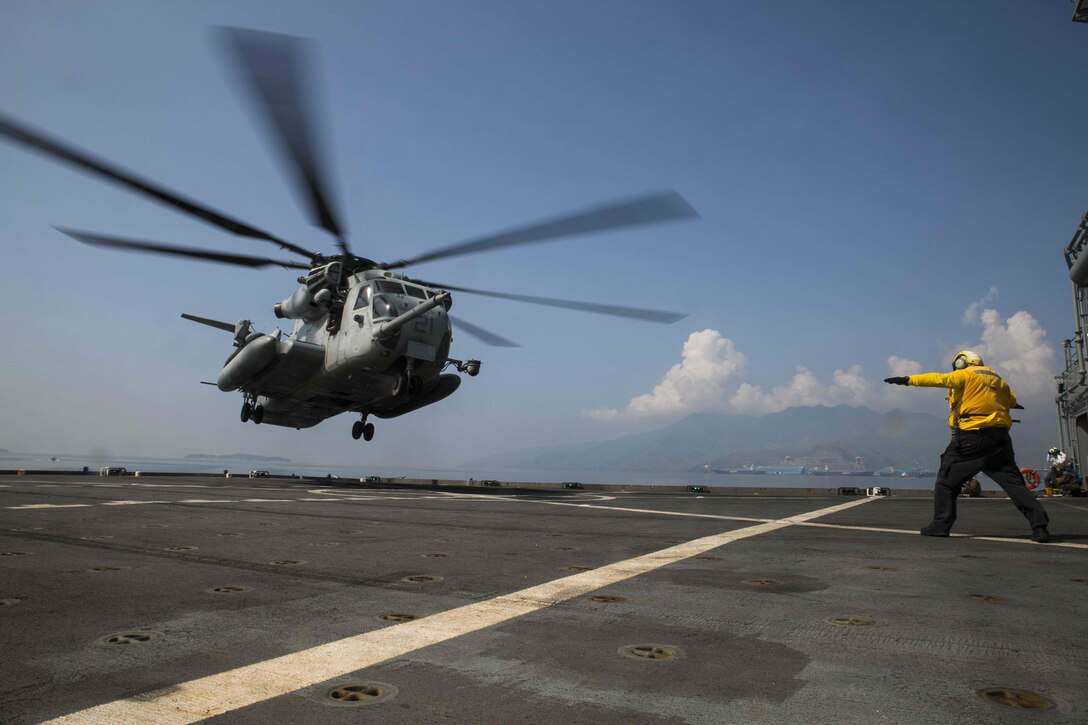 A civilian mariner directs a CH-53E Super Stallion helicopter during a landing Oct. 1 on the flight deck of the USNS Sacagawea in Subic Bay, Philippines. Marines are taking part in exercise T-AKE 14-2, a maritime pre-positioned force, multi-country theater security cooperation event that deploys from Okinawa to conduct training exercises throughout the Pacific area of operations. Recently, the Marines have been providing logistical support during PHIBLEX, an annual bilateral training exercise conducted by the Armed Forces of the Philippines alongside U.S. Marine and Navy forces. The aircraft is with Marine Medium Tiltrotor Squadron 262 (Reinforced), 31st Marine Expeditionary Unit, currently assigned to 3rd Marine Expeditionary Brigade.