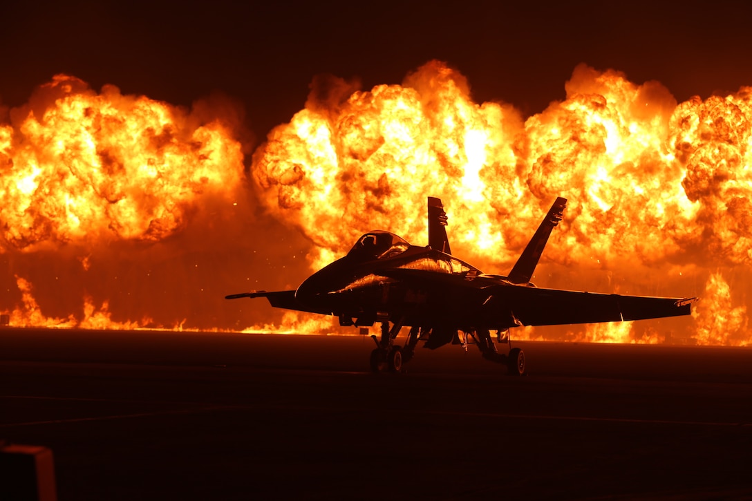 Flames explode behind the U.S. Navy Blue Angels'  F/A-18 Hornets during the night portion of the 2014 Miramar Air Show aboard Marine Corps Air Station Miramar, Calif., Oct. 4. The wall of fire is the last event of the night air show.