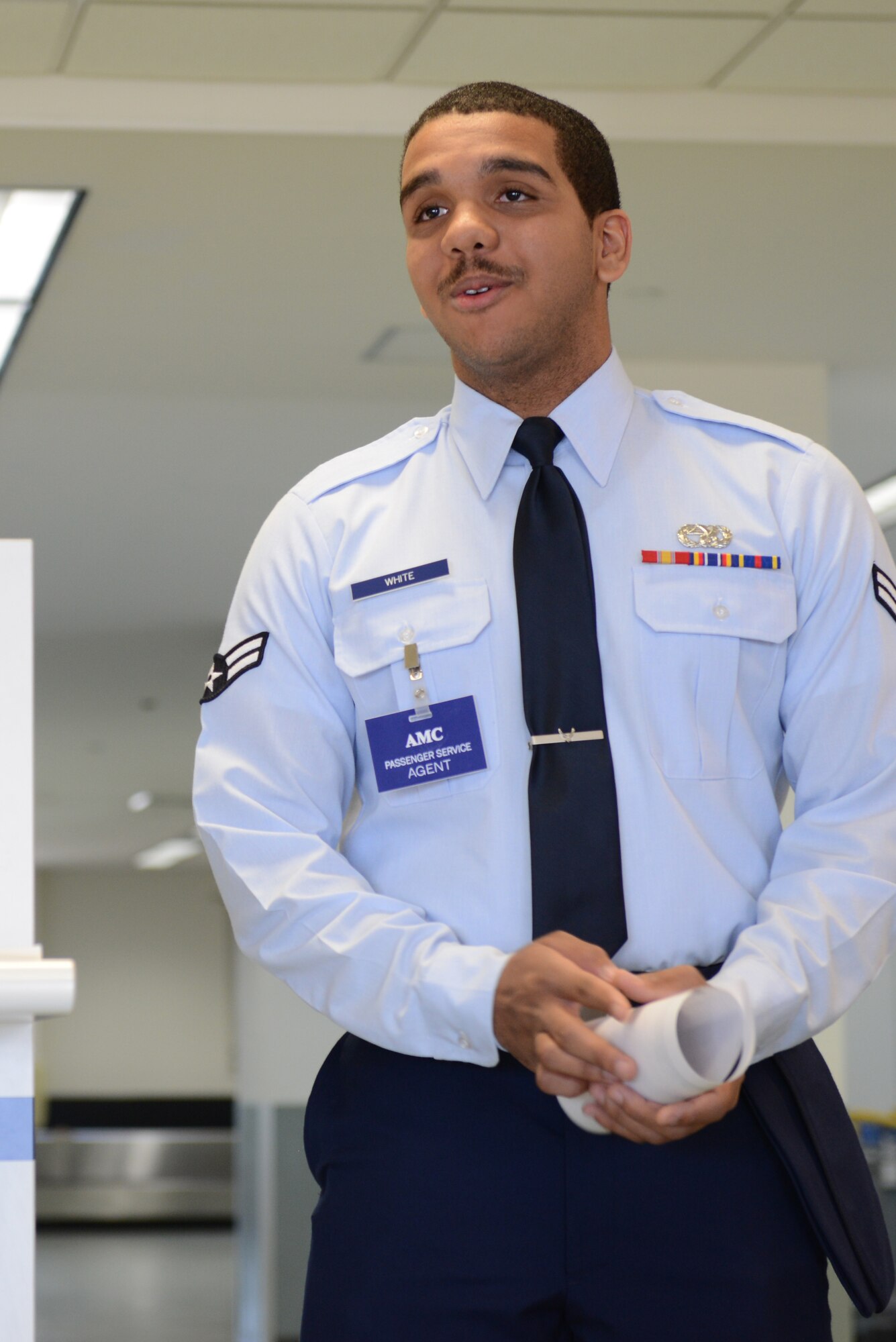 Airman 1st Class Cameron White, 730th Air Mobility Squadron passenger service agent, briefs base personnel at the 730 AMS open house at Yokota Air Base, Japan, Sept. 29, 2014. White was one of four representatives chosen to answer questions on topics such as environmental morale leave, categories for space available flights and documentation needed for pets during a PCS. (U.S. Air Force photo by Airman 1st Class David C. Danford/Released)