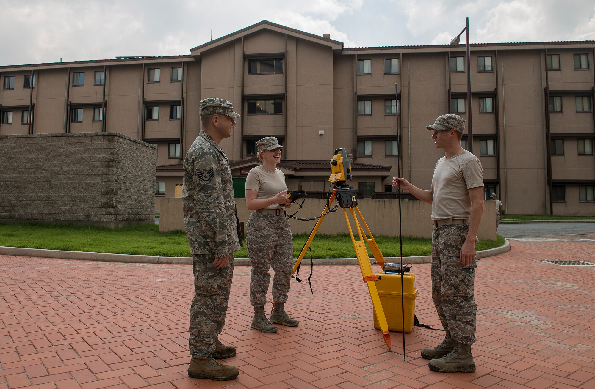 Airman 1st Class Andrew Riesenberger, a 51st Civil Engineer Squadron engineering technician, chats with his coworkers during a job Sept. 4, 2014, at Osan Air Base, Republic of Korea. As an engineering technician, Riesenberger and his coworkers are reponsible for mapping and surveying the base. (U.S. Air Force photo by Staff Sgt. Jake Barreiro/Released)