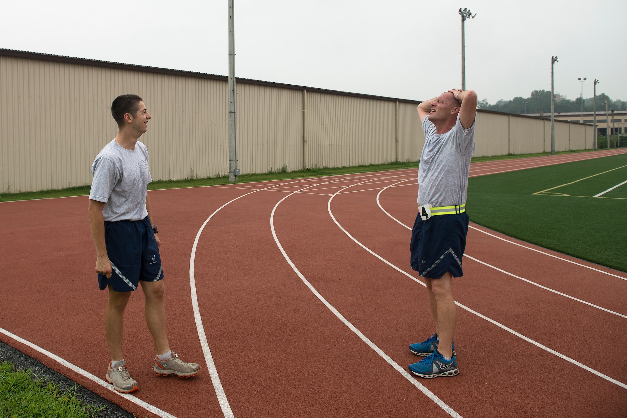 Staff Sgt. Joshua Johnson, a 51st Operations Support Squadron airfield management operations supervisor, cools down with a coworker after running with him for a PT test Aug. 7, 2014, at Osan Air Base, Republic of Korea. Johnson does a variety of fitness-related activity within his squadron, including leading PT sessions and off-duty running. (U.S. Air Force photo by Staff Sgt. Jake Barreiro/Released)