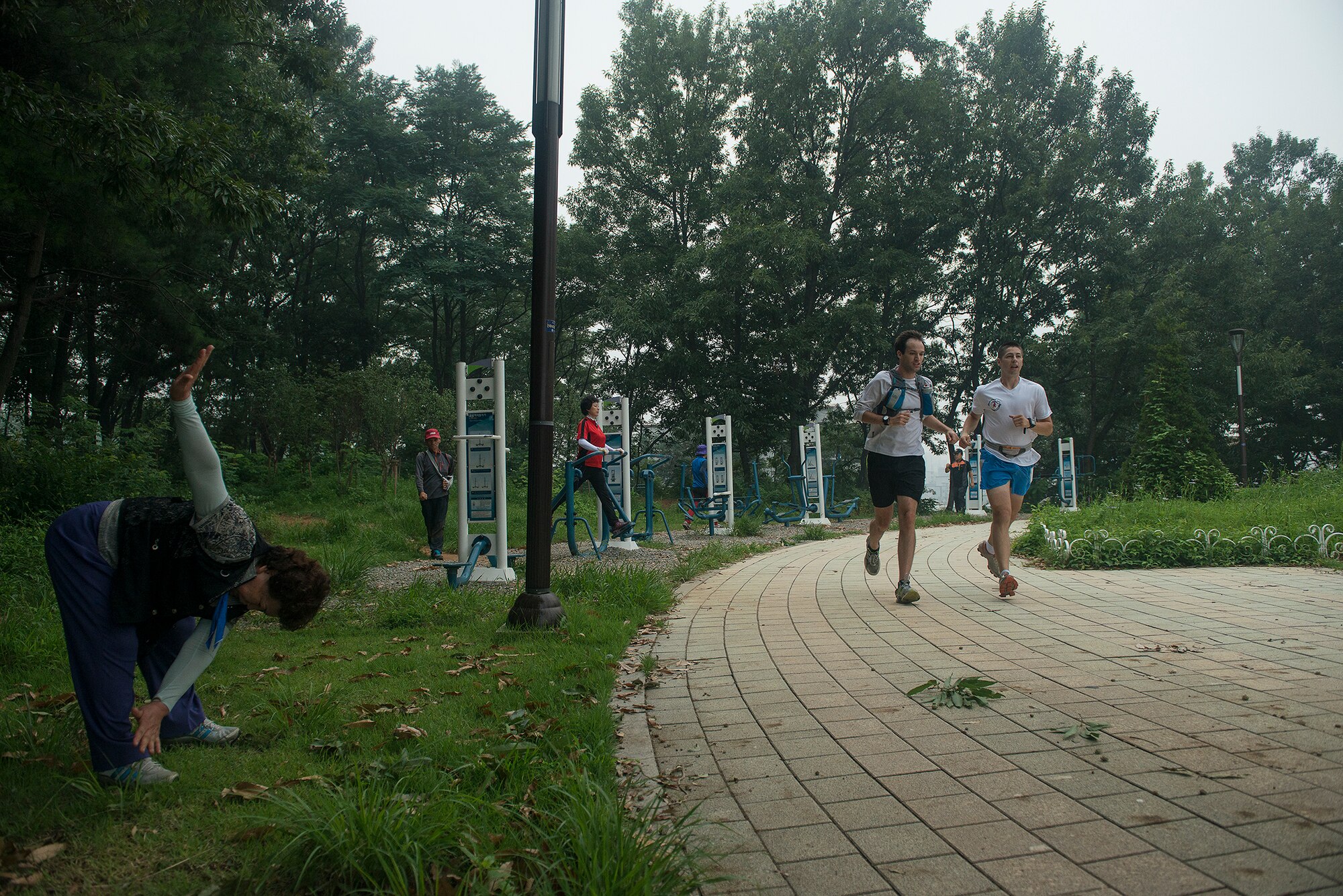 Staff Sgt. Joshua Johnson, a 51st Operations Support Squadron airfield management operations supervisor, runs with a friend Aug. 6, 2014, in Pyeongtaek, Republic of Korea. Johnson enjoys training with other people, and uses running as a chance to broaden his social circle, meet new people, and stay in shape.  (U.S. Air Force photo by Staff Sgt. Jake Barreiro/Released)