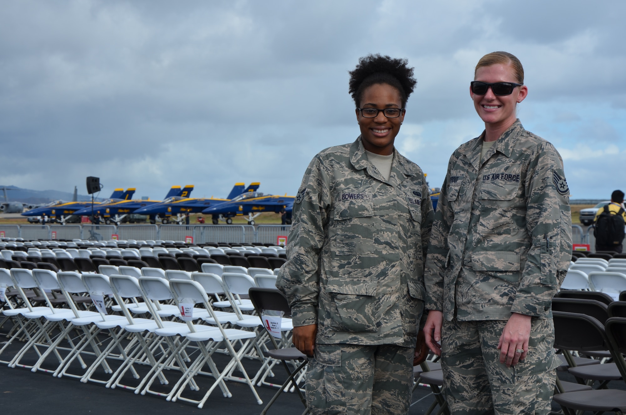 Senior Airman, Demi Bowers, left, a knowledge operations craftsman with the 624th Regional Support Group, and Staff Sgt. Emily Sprout, a medical administrator with the 624th Aeromedical Staging Squadron, pose for a photo in front of the Blue Angels F/A-18 Hornets after escorting a group of special needs children to a private viewing of  the demonstration team’s practice, Joint Base Pearl Harbor-Hickam, Hawaii, Sept. 26, 2014. Members of the 624th Regional Support Group provided media and community relations escort for special events leading up to the “Wings Over the Pacific” air show held at Hickam Field, Hawaii, Sept. 27-28, 2014. (U.S. Air Force photo by Tech. Sgt. Phyllis Keith)
