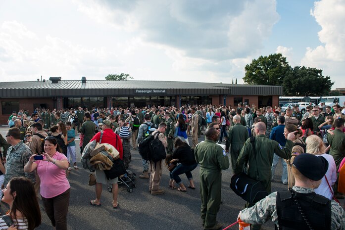 Members of the 15th Airlift Squadron return to their loved ones after arriving home from a deployment Oct. 2, 2014, at Joint Base Charleston, S.C. The 15th Airlift Squadron is returning home after a two-month deployment to Southwest Asia.  Under the new Lead Wing Construct, the 15th Airlift Squadron was responsible for all three deployed C-17 bases in the Persian Gulf, executing up to 98 combat missions a week. With a 47 percent increase in manning requirements, the 15th AS received help from every one of Joint Base Charleston's active-duty sister squadrons, every 315th Airlift Wing Reserve Squadron and the Memphis Air National Guard.  They formed a formidable Total Force Integration team with phenomenal executional results that delivered more than 73 million pounds of cargo flying more than 4,400 combat hours. (U.S. Air Force photo/Senior Airman George Goslin)