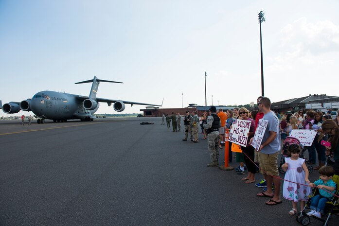 Family members and loved ones await the return of the members from the 15th Airlift Squadron during their redeployment, Oct. 2, 2014, at Joint Base Charleston, S.C. The 15th Airlift Squadron is returning from a two-month deployment to Southwest Asia.  Under the new Lead Wing Construct, the 15th Airlift Squadron was responsible for all three deployed C-17 bases in the Persian Gulf, executing up to 98 combat missions a week. With a 47 percent increase in manning requirements, the 15th AS received help from every one of Joint Base Charleston's active-duty sister squadrons, every 315th Airlift Wing Reserve Squadron and the Memphis Air National Guard.  They formed a formidable Total Force Integration team with phenomenal executional results that delivered more than 73 million pounds of cargo flying more than 4,400 combat hours. (U.S. Air Force photo/Senior Airman George Goslin)