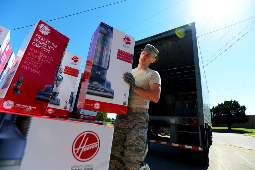 U.S. Air Force Staff Sgt. Harvey Wells, 20th Civil Engineer Squadron Airman dormitory leader, unloads a shipment of vacuum cleaners at Shaw Air Force Base, S.C., Oct. 6, 2014. Due to outdated and broken vacuums, 150 new vacuums were purchased to help dorm residents maintain clean facilities. (U.S. Air Force photo by Airman 1st Class Jensen Stidham/Released)