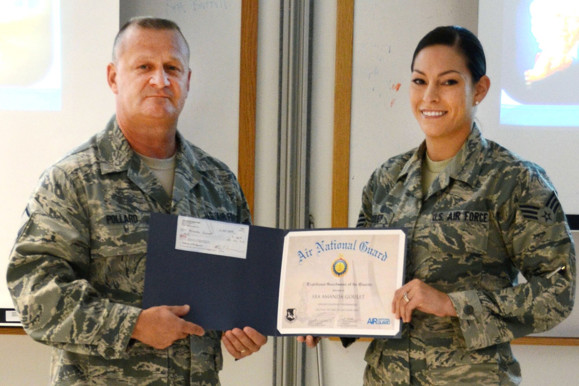 Master Sgt. Dan Pollard presents a certificate to Senior Airman Amanda Goulet, 157th Medical Group Bioenvironmental technician, for being selected as the New Hampshire Air National Guard Traditional Guard Person of the Quarter at the medical group's roll call Oct. 4, 2014. (U.S. Air National Guard photo by Airman 1st Class Kayla McWalter)

