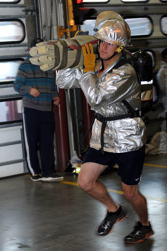 First Lt. Jeffrey Mellgren, 28th Civil Engineer Squadron officer in charge of requirements and optimization, participates in a hose carry during a firefighter challenge at Ellsworth Air Force Base, S.D., Oct. 3, 2014. The purpose of Fire Prevention Week is to raise awareness of fire safety and educate Airmen on escape routes planning in the event of a house fire. (U.S. Air Force photo by Senior Airman Hailey R. Staker/Released)    