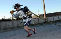 Staff Sgt. Matthew Phillips, 28th Security Forces Squadron vehicle control officer, participates in a hose drag during the firefighter challenge at Ellsworth Air Force Base, S.D., Oct. 3, 2014. The event kicked off the annual Fire Prevention Week, which runs from Oct. 6-13 and includes an open house and a parade. (U.S. Air Force photo by Senior Airman Hailey R. Staker/Released)