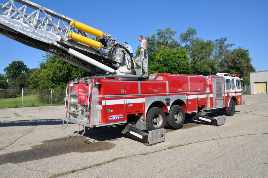 WRIGHT-PATTERSON AIR FORCE BASE, Ohio - Senior Airman Jonathan Porter, 445th Logistics Readiness Squadron, takes instruction from Mr. Bob Erbaugh, a master fire technician contractor with the company, Parson, while Senior Airman Anthony Dann watches during the fire truck training provided to the 445th LRS Squadron Sept. 7, 2014. (U.S. Air Force photo/Maj. Demetrius Smith)